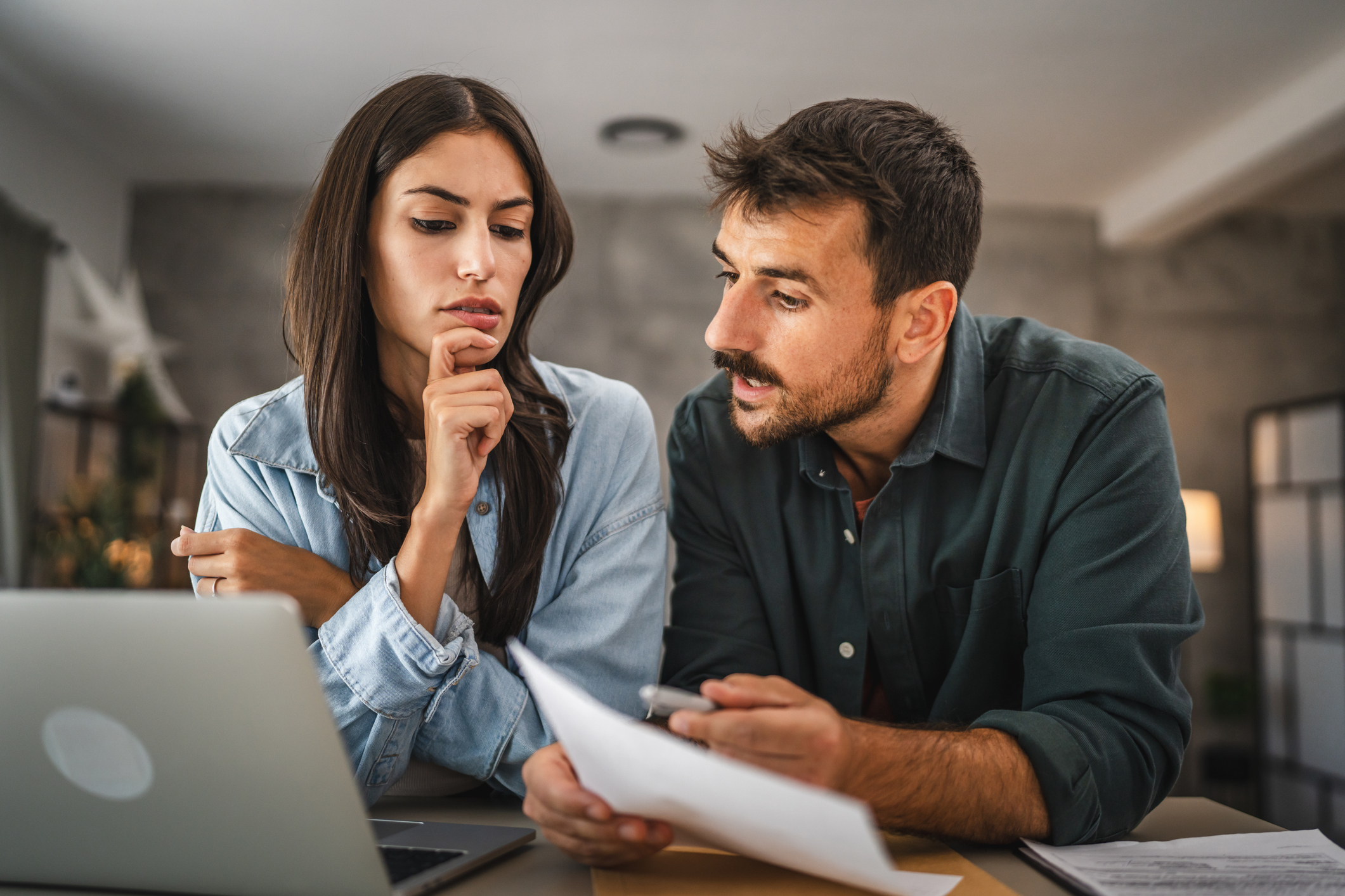 couple boyfriend and girlfriend read together letter from envelope near laptop